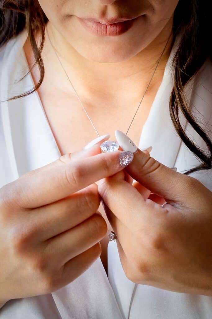 Close-up of woman holding wireless earbuds, emphasizing modern technology and style.