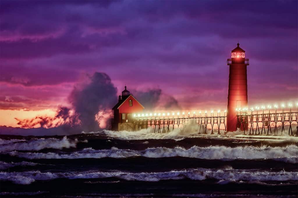 Lighthouse on the coast during sunset with vibrant purple and pink sky.